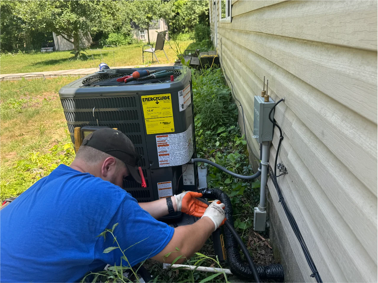 An HVAC tech takes measurements of an outdoor HVAC system