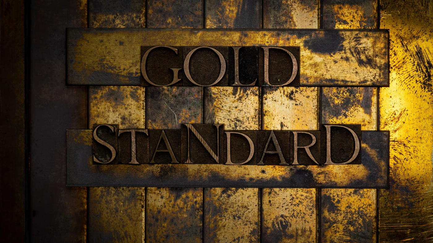A gold plate with the words Gold Standard stamped on it