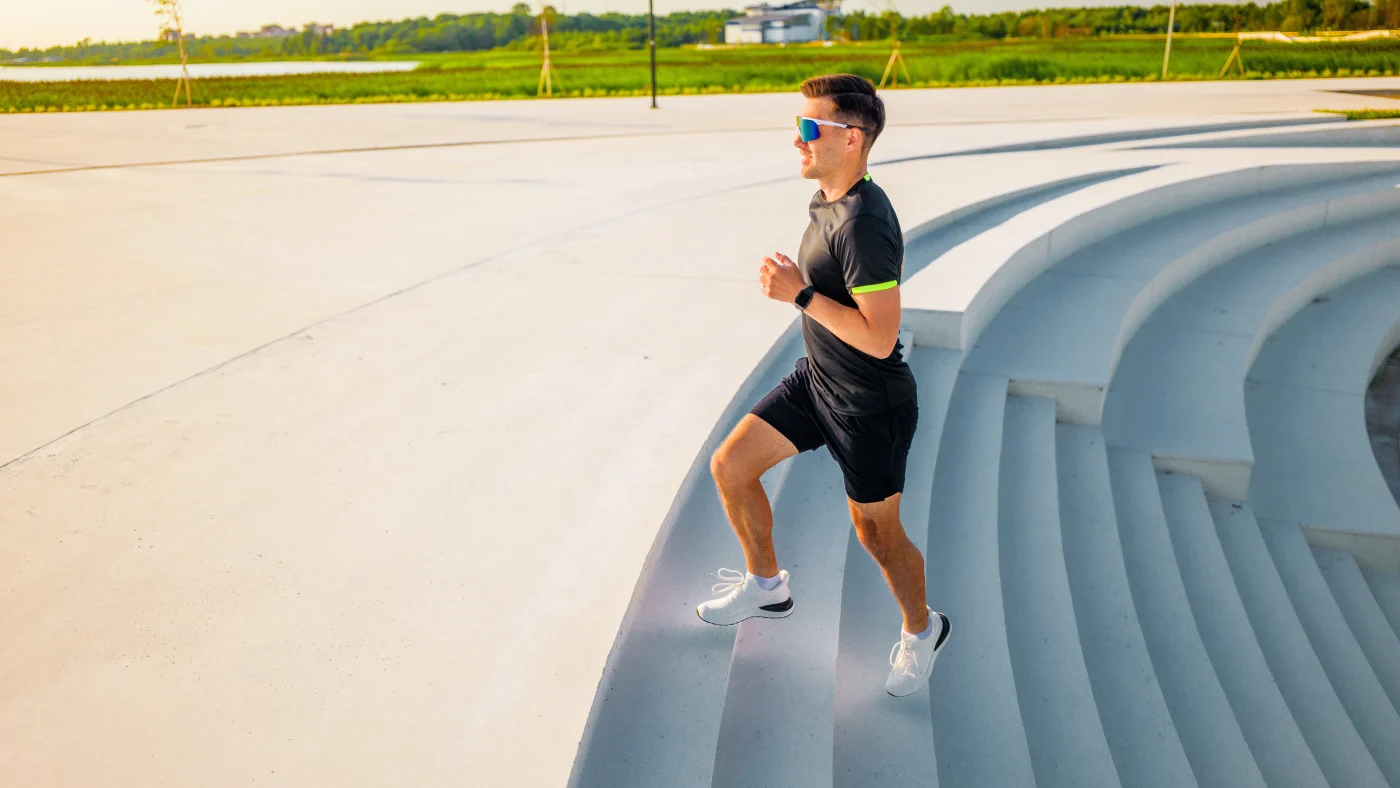 A runner jogs up steps in a park